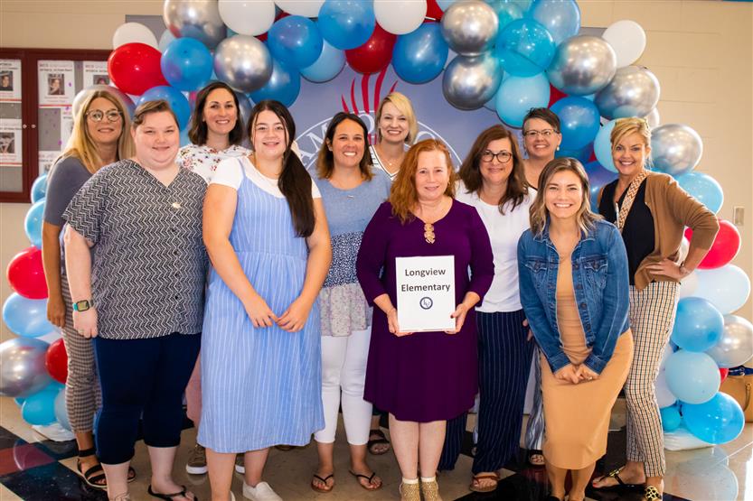 A group of teachers smile